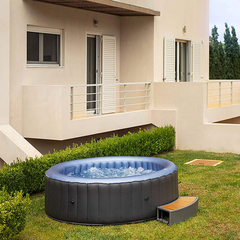 Inflatable Jacuzzi set up in a garden next to a house, with water jets activated.