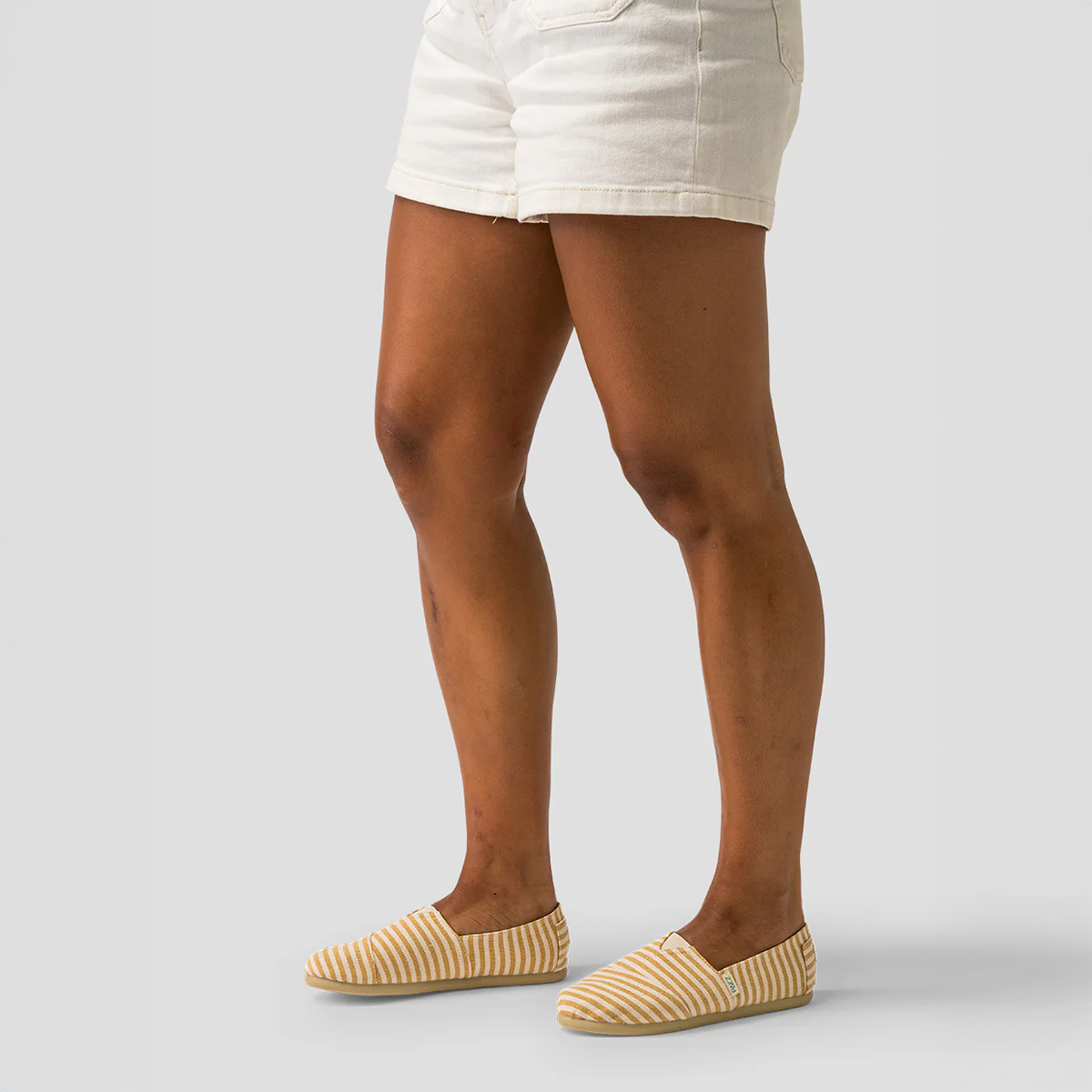 Caramel PAEZ Surfy espadrille shoes for women, featuring caramel and cream striped fabric, styled with white shorts against a plain grey background.